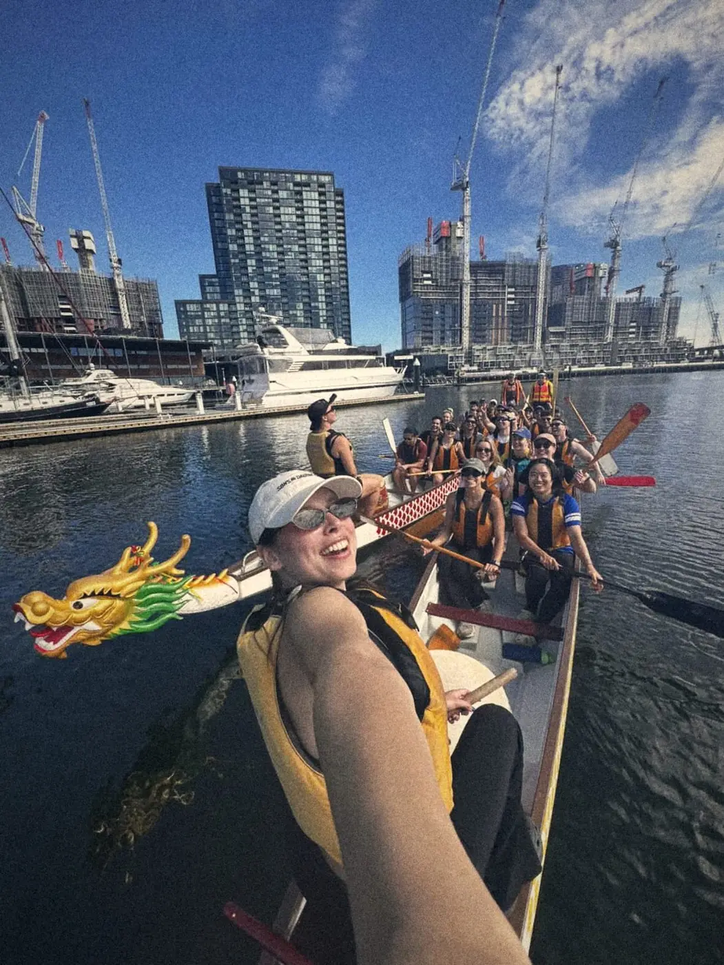 A dragon boat crew grinning at the camera after a race